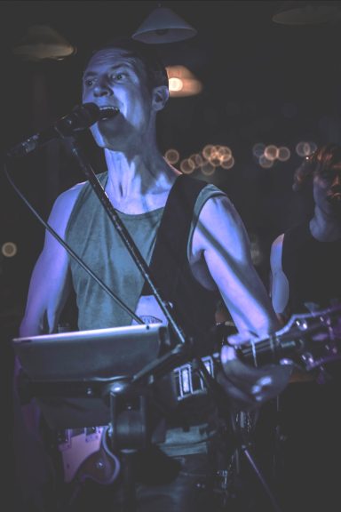 Live Konzert im Sir Capulus Füssen: Boulevard of Rock auf der Bühne. Sänger mit E-Gitarre bei einem Live-Konzert im Sir Capulus in Füssen, Bühnenlicht und Konzertstimmung in der Bard im Allgäu.